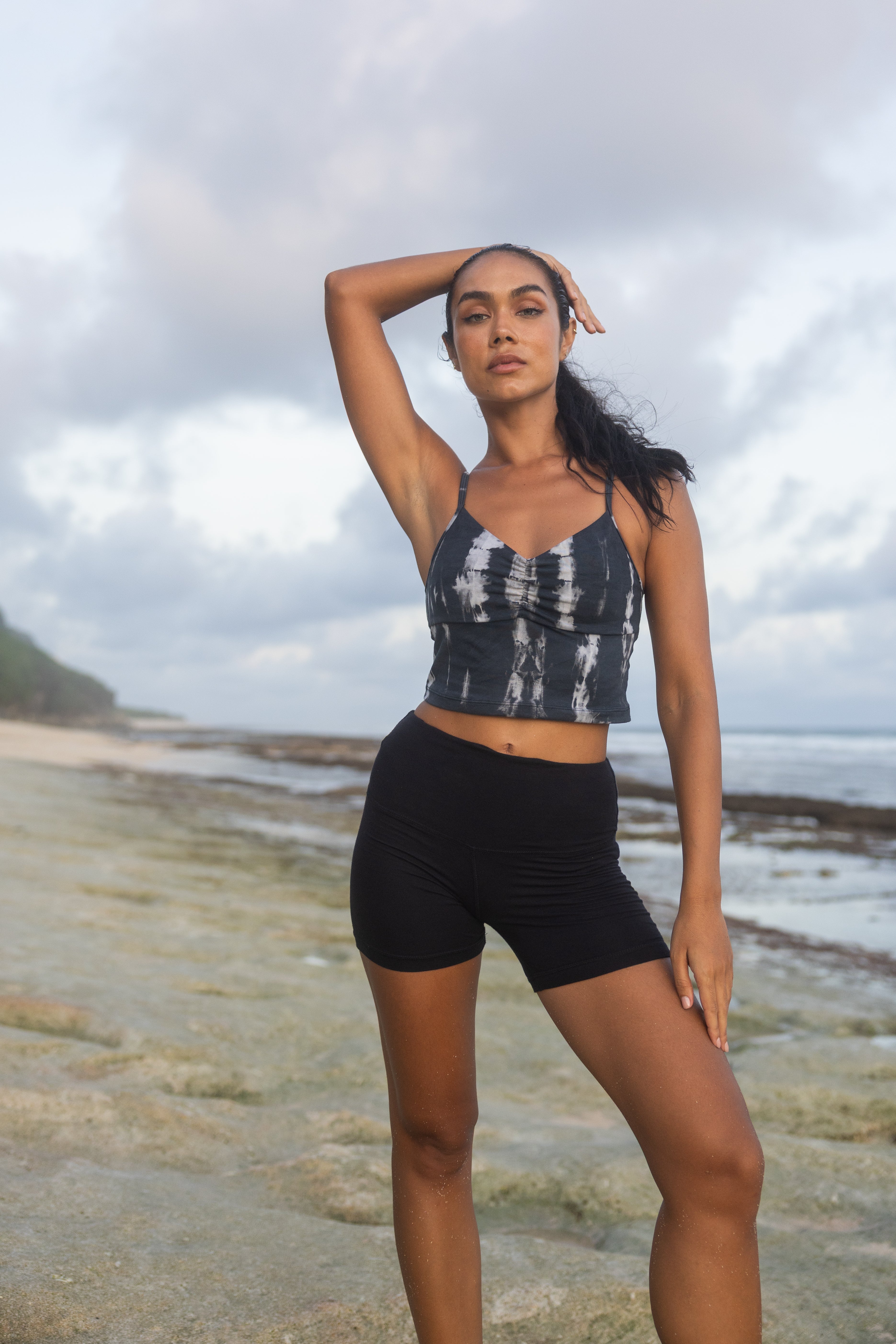 Black tie-dye bamboo crop top with ruched front – beach setting

High-waisted black bamboo yoga shorts with strappy tank

Sustainable activewear for women in black and tie-dye

Bamboo yoga set with ruched tank top and lounge shorts

Eco-friendly tie-dye crop top and black yoga shorts

Moisture-wicking bamboo workout outfit for women

Natural fiber fitness clothing in black and white tie-dye

Stylish bamboo activewear for yoga, lounging, or light training